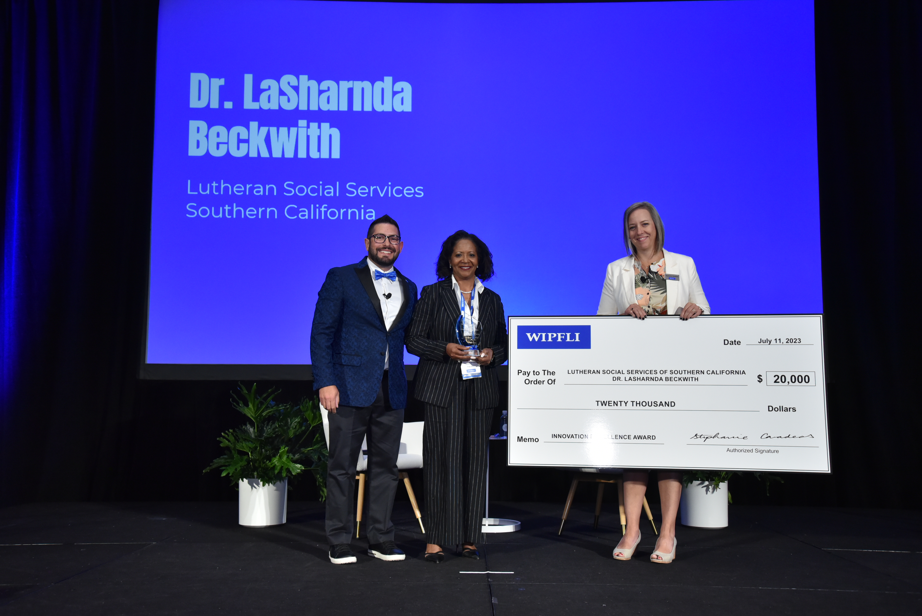 LaSharnda Beckwith, center, receives the 2023 Innovation Excellence Award at the Stronger  to Serve conference from Wipfli principal George Persekian, left, and Wipfli partner Stephanie  Cavadeas, right, representing the Wipfli Foundation. Beckwith leads Lutheran Social Services of Southern California.