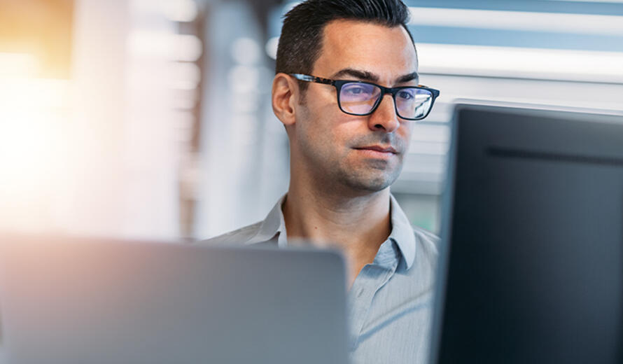 A guy in front of computer screen in the picture.