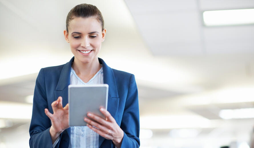 Shot of a young office worker standing in an office using a digital tablet