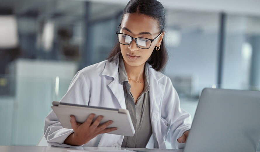 woman healthcare worker on tablet and laptop